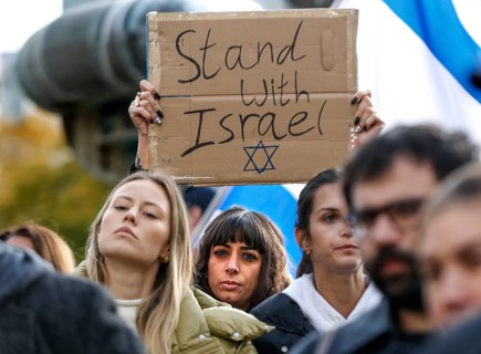 A participant in the demonstration Solidarity March with Israel shows a poster with the inscription Stand with Israel