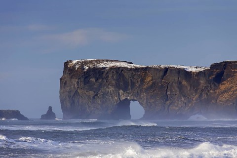 Black arch of lava near Vik i Myrdal at the Dyrholaey peninsula in winter