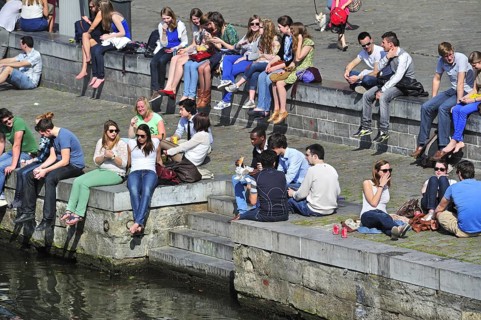 People enjoying the first spring sun by the waterside along the Graslei at Ghent