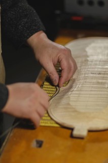 Unrecognizable luthier lute maker artisan hands in his workshop try