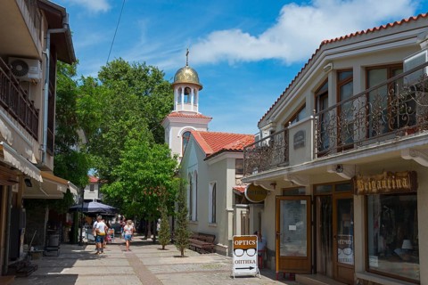 Pedestrian zone with people strolling between shops and a church