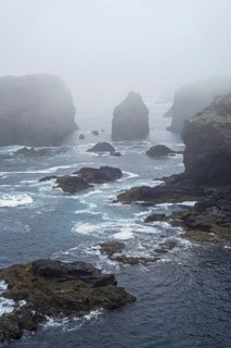 Sea stacks and sea cliffs in mist during stormy weather at Eshaness