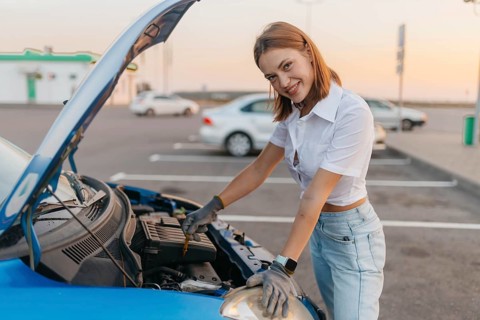 Young beautiful hot girl driver checks oil level