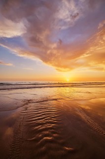 Atlantic ocean sunset with surging waves at Fonte da Telha beach, Costa da Caparica, Portugal,