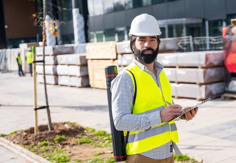 Engineer with an amputee leg working on site in the street next to a building