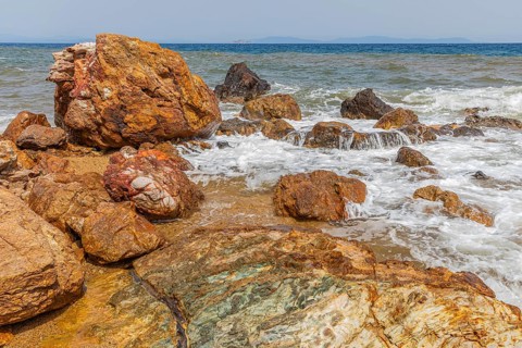 Mineral rocks washed by the sea on the beach of Topinetti, near Rio Marina, Elba, Tuscan