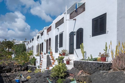 Typical white houses on the promenade, with small gardens on lava rock, Puerto del Carmen,