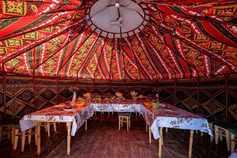 Set table and chairs in a colourful yurt, yurt with traditional patterns, Naryn region, Kyrgyzstan,