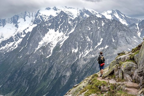 Mountaineer on hiking trail, glaciated rocky mountain peaks Hoher Weisszint, Berliner Hoehenweg,