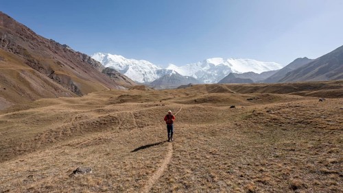 Mountaineers in the Achik Tash valley, in the background glaciated and snow-covered mountain peak