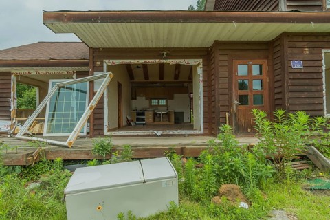 Daejeon, South Korea, June 29, 2018: Old refrigerator laying in front of abandoned two story house,