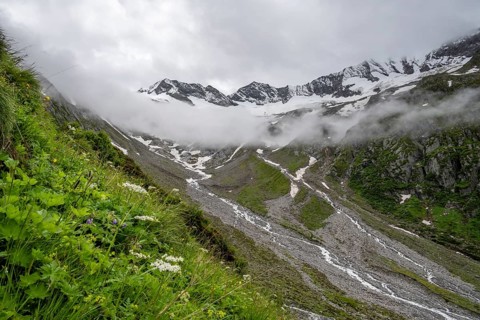 Cloudy valley of the Schlegeisgrund with mountain stream, glaciated mountain peaks Hoher Weiszint