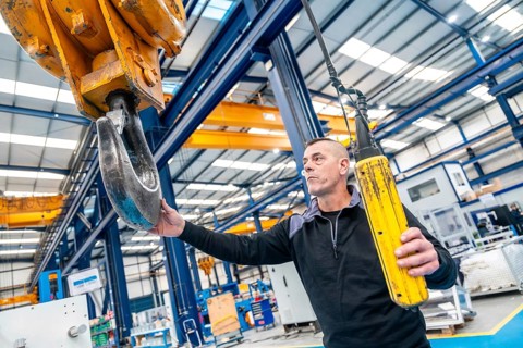 Worker using a huge industrial cane working in a logistics center