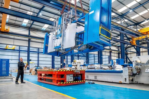 Horizontal photo with copy space of a crane lifting very heavy machinery in a factory