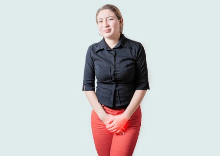 Young woman suffering with urinary problems isolated. Girl with hands on crotch with urinary