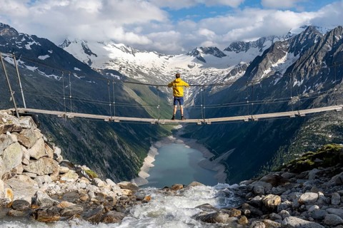 Mountaineers on a suspension bridge over a mountain stream Alelebach, picturesque mountain