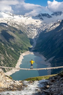 Mountaineers on a suspension bridge over a mountain stream Alelebach, picturesque mountain