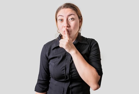 Amazed woman making silence gesture with finger. Blonde girl making silence gesture isolated