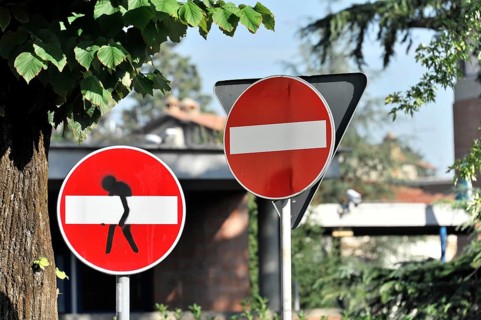 Street signs, with figure modified no entry sign, centre, Assisi, Umbria, Italy, Europe