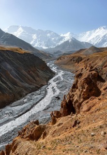 Achik Tash river, Achik Tash valley with rock formations, behind glaciated and snow-covered