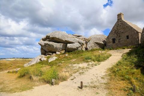 Former village of Meneham on the Atlantic coast with partly thatched houses between granite rocks,