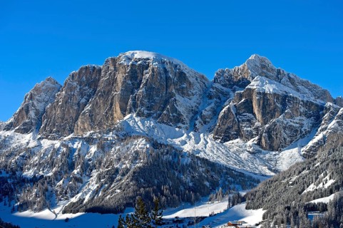 Snow-covered peak Sass de Ciampac above the mountain village of Colfosco, Colfosco, winter sports
