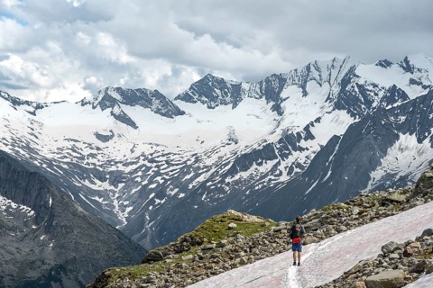 Mountaineer on hiking trail with snow, Berliner Hoehenweg, mountain landscape with glaciated peaks