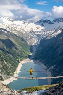 Mountaineers on a suspension bridge over a mountain stream Alelebach, picturesque mountain