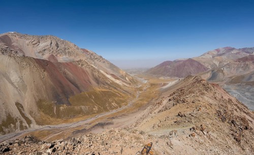 Mountain landscape of glacial moraines, mountains with red and yellow rocks, Traveller's Pass below