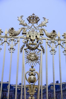 Emblem of the Sun King with Apollo's head, sunbeams and sceptre with French lily on the royal