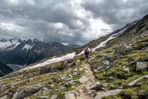 Mountaineer on hiking trail, Berliner Hoehenweg, mountain landscape with glaciated peaks Hochfeiler