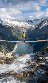 Mountaineers on a suspension bridge over a mountain stream Alelebach, picturesque mountain
