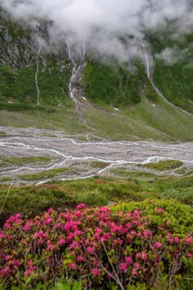 Mountain streams flow over steep mountain slopes into the Schlegeisgrund valley, cloudy rocky
