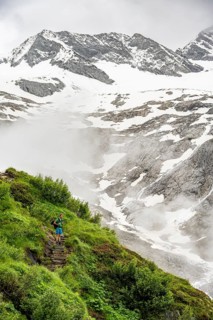 Mountaineers on a hiking trail, in the background glaciated peak Dosso Largo and glacier