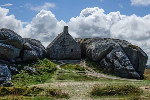 Former village of Meneham on the Atlantic coast with partly thatched houses between granite rocks,