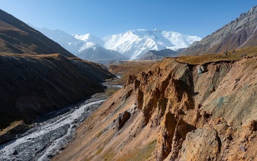 Achik Tash river, Achik Tash valley with rock formations, behind glaciated and snow-covered