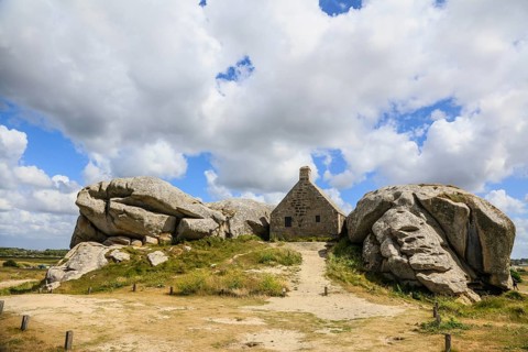 Former village of Meneham on the Atlantic coast with partly thatched houses between granite rocks,