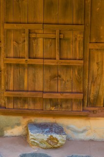 Oriental wooden door that slides to open and close on old stucco building