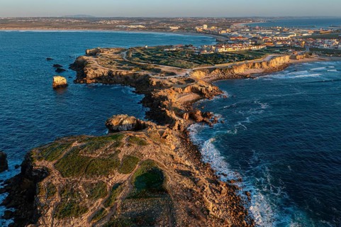 Aerial landscape of Peniche, Portugal, peninsula and town at sunset. Summer sunset haze, little