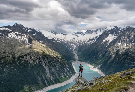 Mountaineer on a rock in front of a mountain panorama, view of Schlegeisspeicher, glaciated rocky