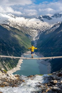 Mountaineers on a suspension bridge over a mountain stream Alelebach, picturesque mountain