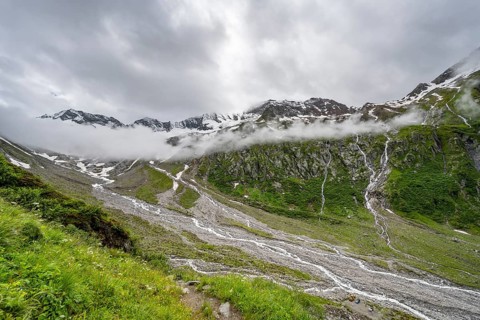 Cloudy valley of the Schlegeisgrund with mountain stream, glaciated mountain peaks Hoher Weiszint