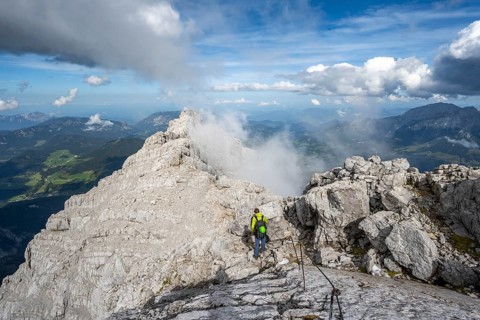 Climber on a via ferrata secured with steel rope, narrow rocky ridge, Watzmann crossing to Watzmann