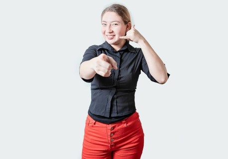 Smiling Beautiful woman gesturing call me and pointing at camera. Friendly girl gesturing call me