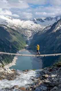 Mountaineers on a suspension bridge over a mountain stream Alelebach, picturesque mountain