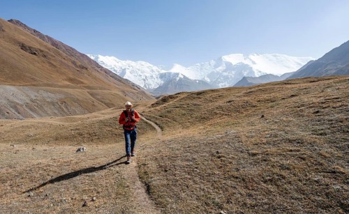 Mountaineers in the Achik Tash valley, in the background glaciated and snow-covered mountain peak