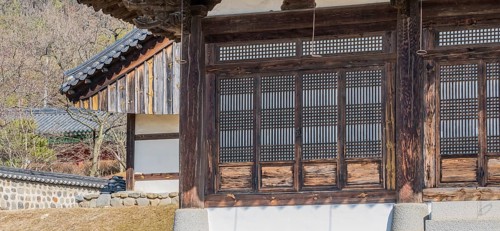 Oriental lattice work on doors of wooden building in a local woodland park in South Korea