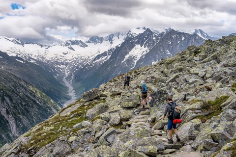 Mountaineer on hiking trail, view of glaciated rocky mountain peaks Hoher Weisszint and Hochfeiler