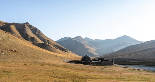 Historic caravanserai Tash Rabat from the 15th century, in the evening light with golden hills,