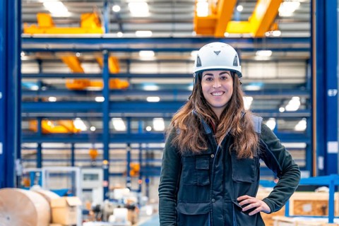 Portrait of a smiling female worker with protective gear standing in a logistic center